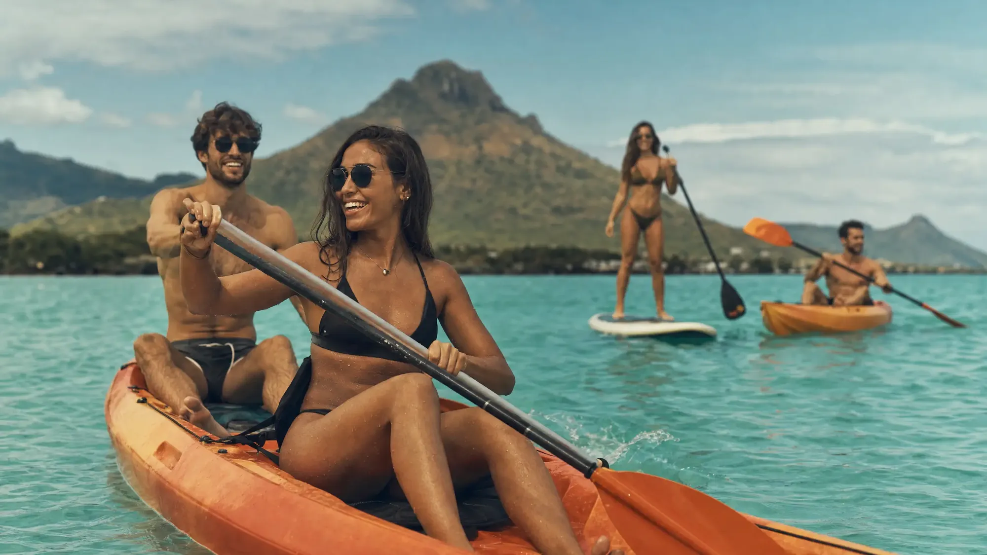 Friends kayaking and paddleboarding on a lagoon in Mauritius