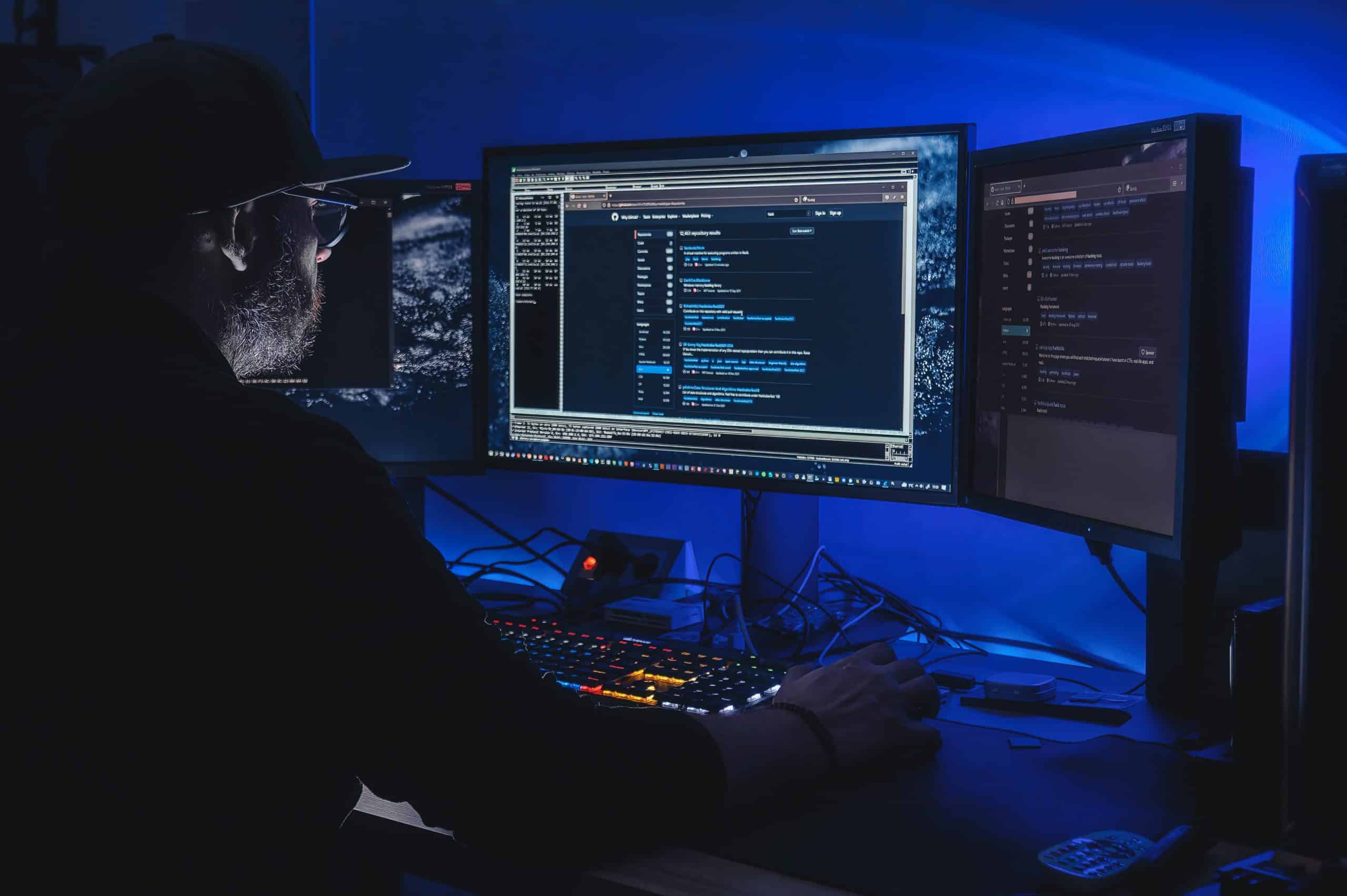 Person coding on multiple computer screens