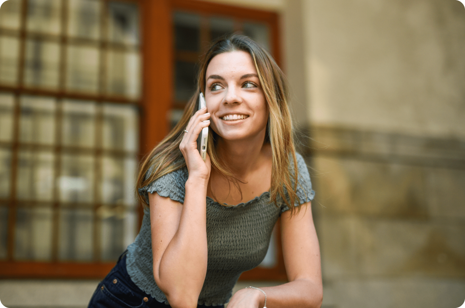 Smiling woman talking on phone outdoors.